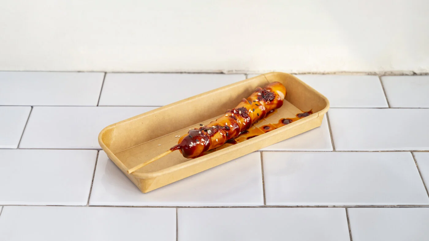 Saucisse grillée à la sauce de Pékin et au sésame, en barquette