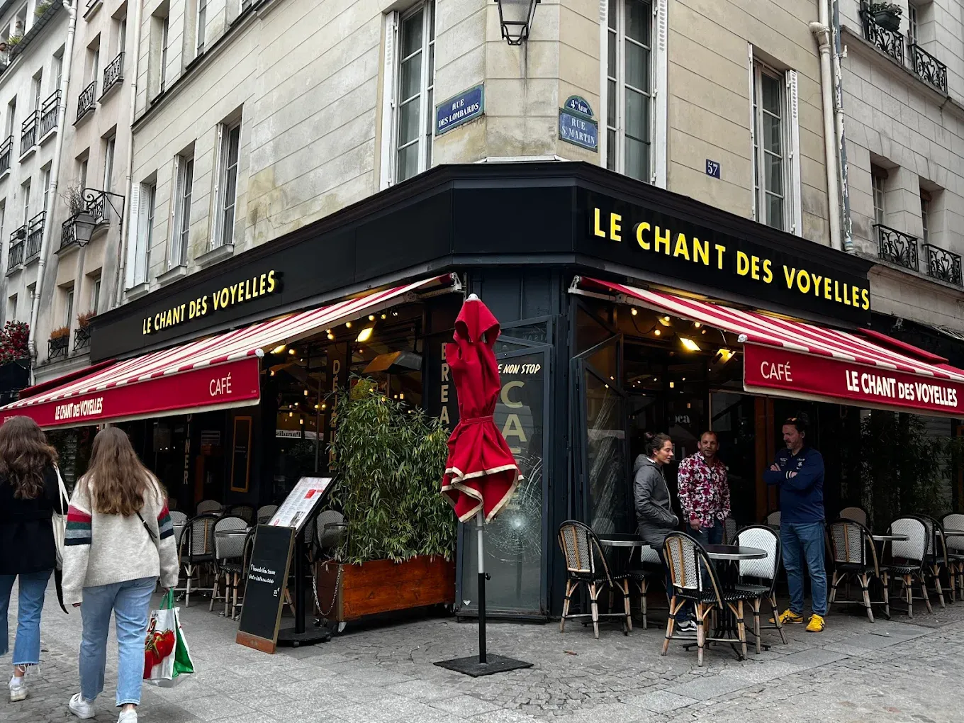 Facade du restaurant a l'angle, enseigne CAFE et stores rouges