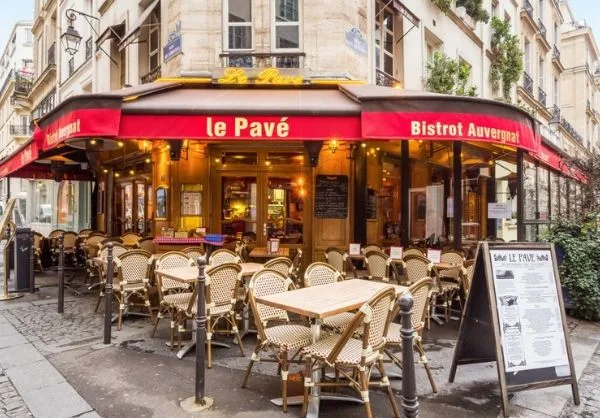 La façade du Pavé rue des Lombards, store rouge « Bistrot Auvergnat » et terrasse en chaises de rotin