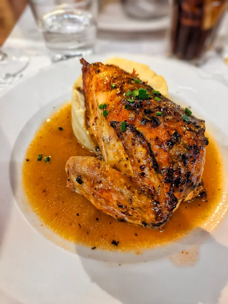 Un poulet jaune du Sud-Ouest rôti, posé sur sa purée maison dans un jus corsé