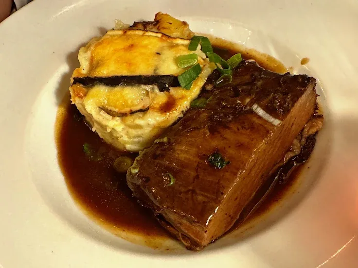 La poitrine confite de bœuf Aubrac dans son jus, à côté du gratin de pommes de terre au saint-nectaire