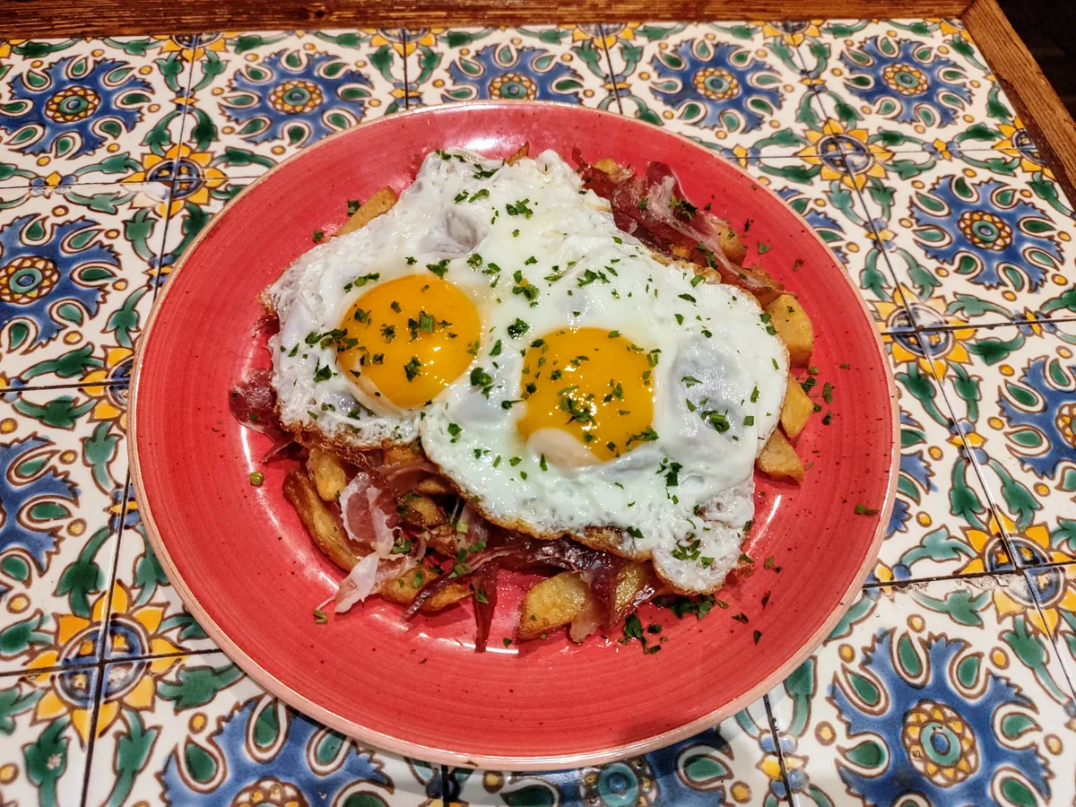 Huevos rotos, œufs au plat sur les frites et le jambon serrano